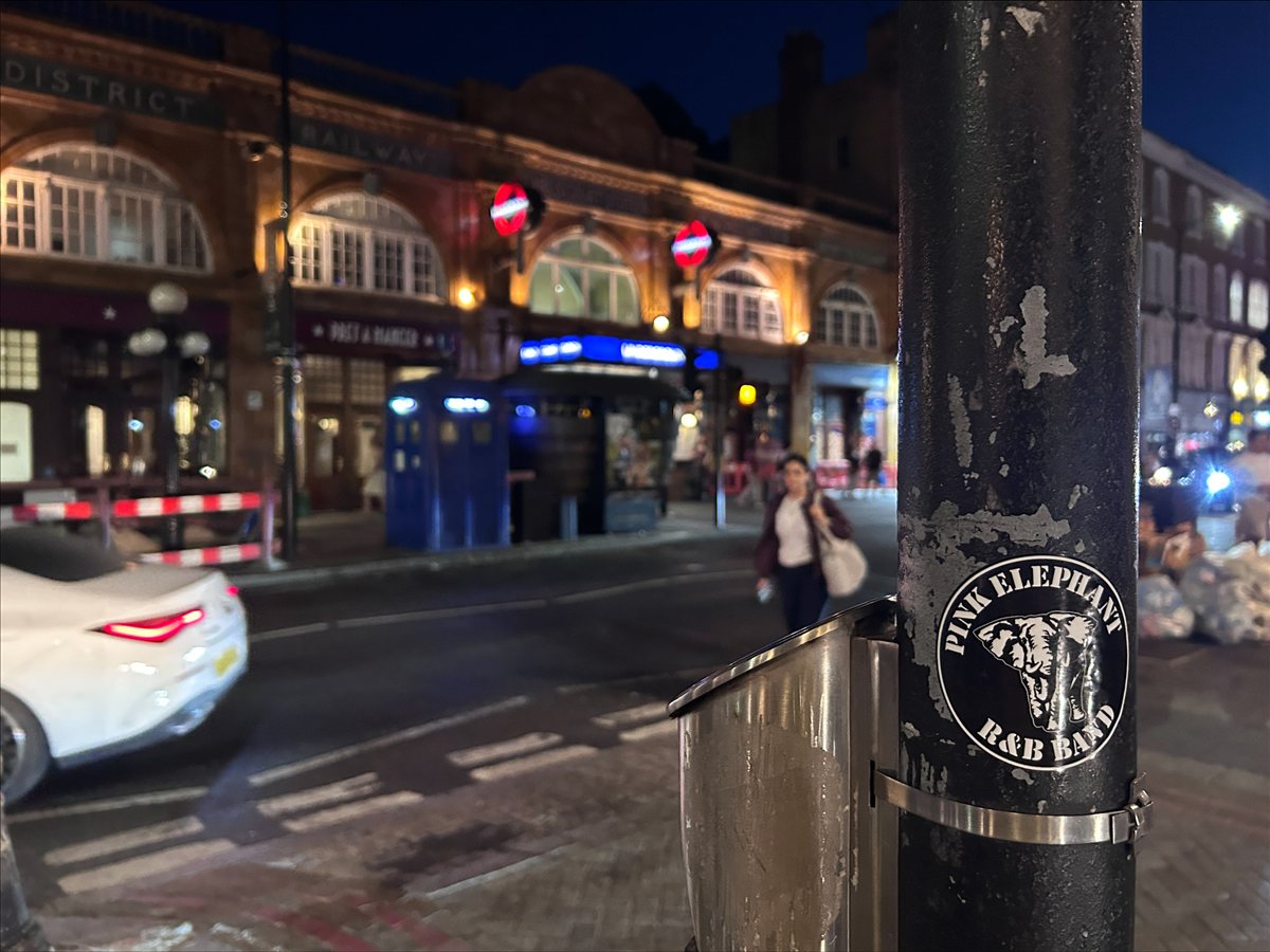 Pink Elephant-klistremerke på en lyktestolpe i London om kvelden