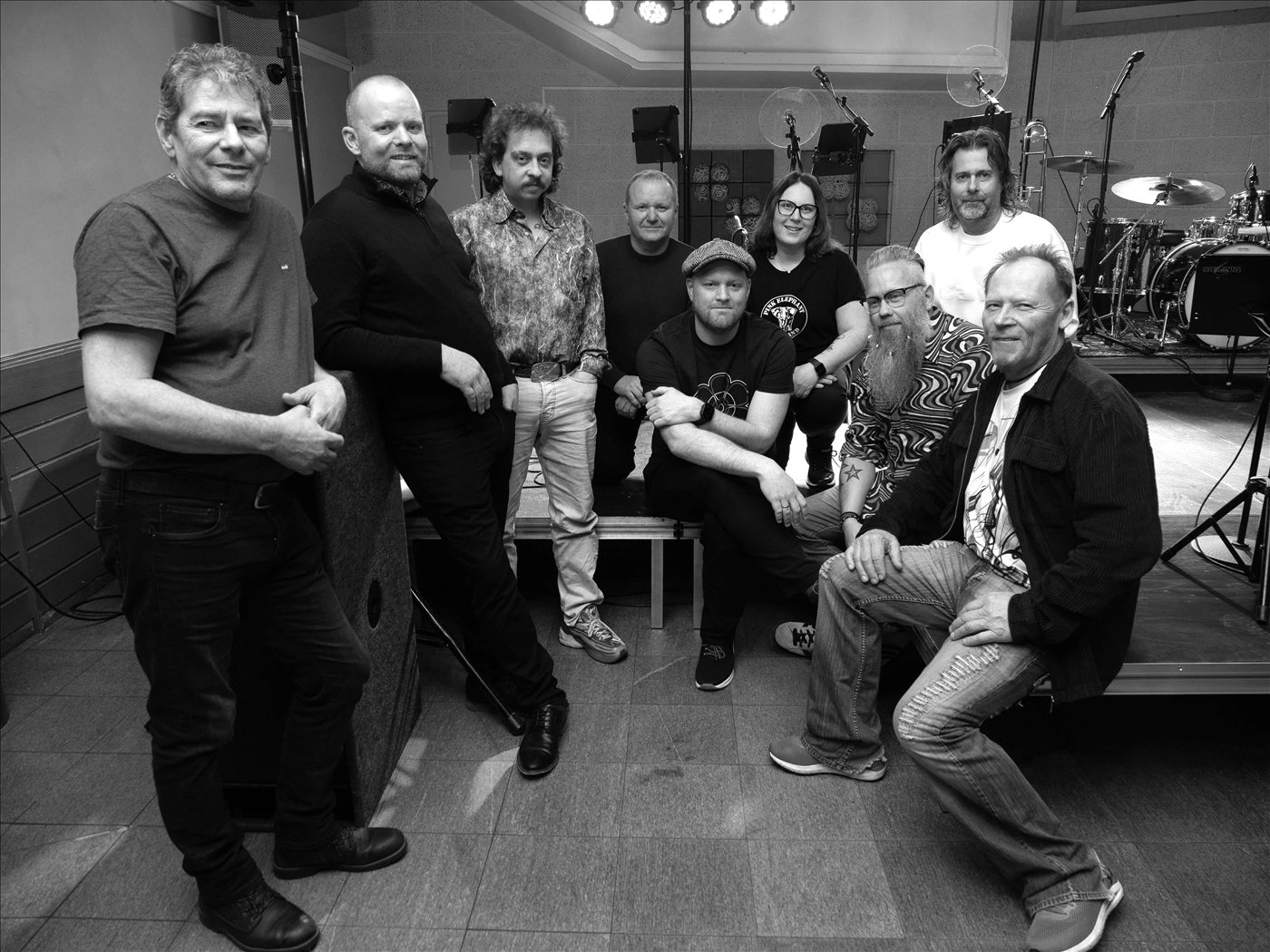 Pressefoto av Pink Elephant R&B Band i svart-hvitt – alle ni medlemmene samlet foran scenen